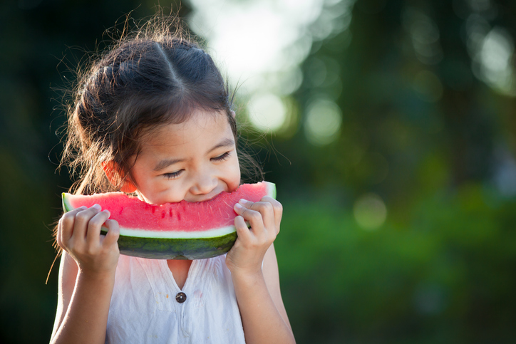 Girl eating watermelon outside